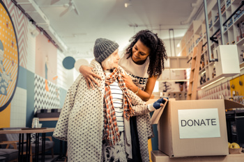 An image of a woman supporting a homeless woman to reduce stigma