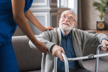 Carer helping up old man