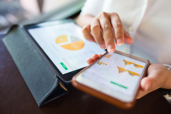 An image to show a woman looking at digital graphs show the social determinants of health