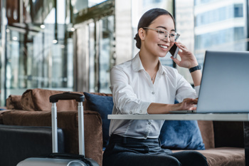 woman on a phone call with laptop in front