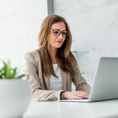 Woman sitting on desk working on her laptop