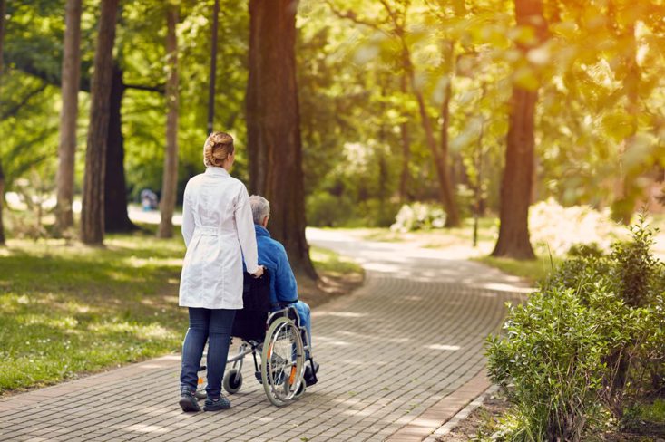 care worker pushing a person on a wheelchair