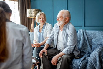 Carer using risk assessment tool with elderly couple