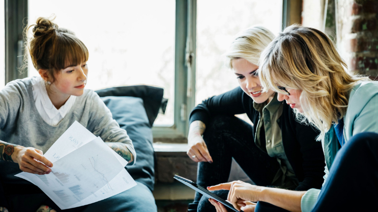 three women looking at documents