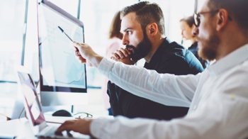 people looking at a computer screen at CQC policies and procedures