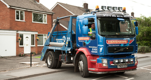 Henshaws skip truck parked outside house