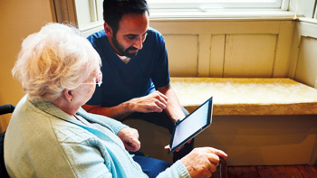 a image of a social care worker working with an older adult to show local health and social care services