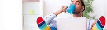 Image of relaxed office worker working from home and drinking coffee