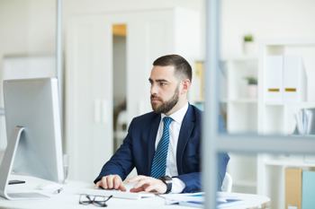 Man in smart suit using computer