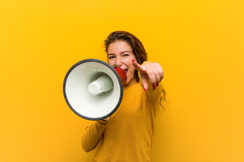 An image of a woman with a megaphone to represent her shouting about the ICB Funding availiable