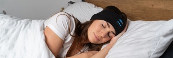 A woman sleeping whilst wearing the SnoozeBand headphones.