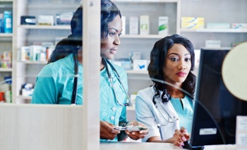 A nurse and pharmacy manager access electronic health records.