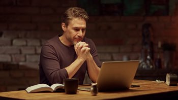Male working from home looking at computer