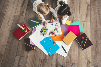 a birdseye image of two girls playing with a jigsaw to show how access elemental can help facilitate social prescribing for children