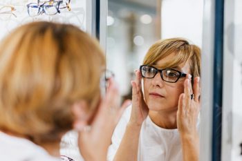 Lady trying on glasses at optician