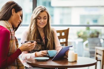 Two young girls in coffees shop demonstrating independent living