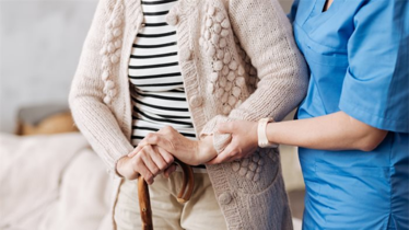 care worker helping an elderly resident walk