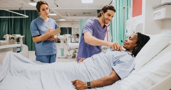 NHS staff attending a patient on a ward.