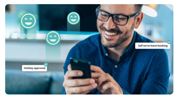 Male in blue shirt smiling at mobile phone