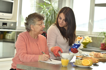 Domiciliary care worker cleaning a lady's home