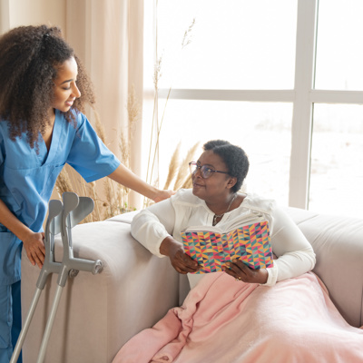 A black woman being comforted by a black female nurse