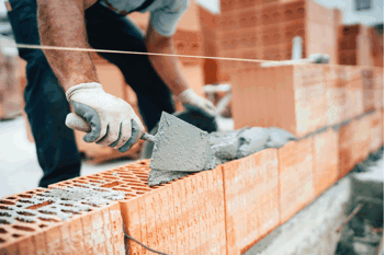 Brick worker laying bricks