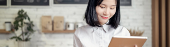 Image of office worker looking at her tablet