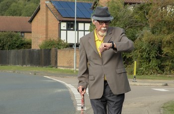 A man walking whilst wearing a wearable device to monitor his condition.