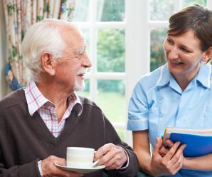 Care worker with elderly man teaching independent living skills