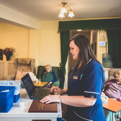 A female nurse in her uniform using a laptop