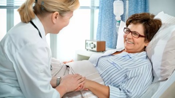 Doctor talking to patient in a bed