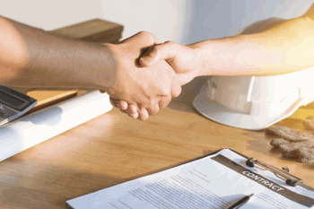 Construction business shaking hands over contract