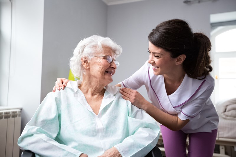 Carer performing fall risk assessment on elderly person