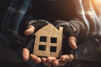 hands holding a cardboard house