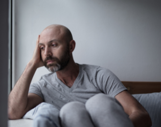 Image of man depressed to show the importance of wellbeing coaches 