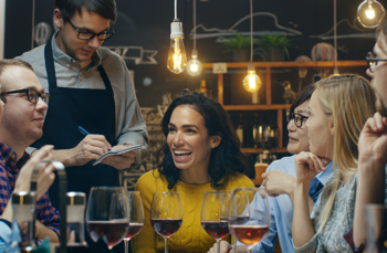 a group of customers enjoying a restaurant served by waiter