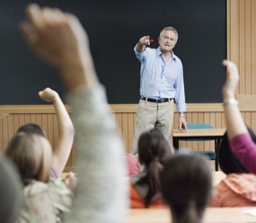 A university lecturer answering questions in a lecture hall.