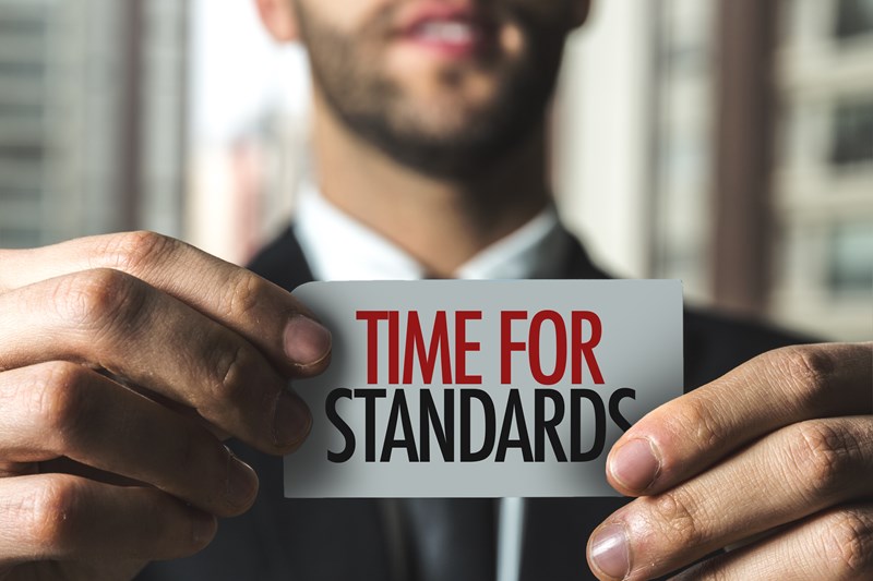 photo of man holding sign saying time for standards to represent the challenges in commissioning social care