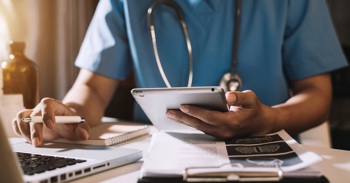 A nurse checking virtual ward patient data.