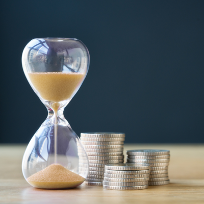 An hourglass and coins